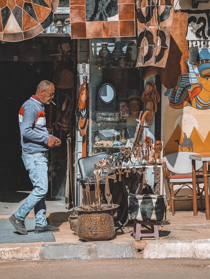 Man browsing a Cairo street market with traditional Egyptian art and crafts on display.